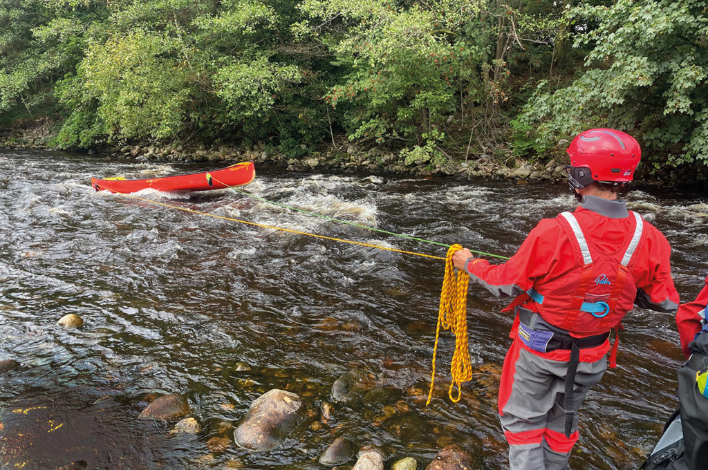 how the ropes are handled from shore. The angle of the canoe has the upstream end of the canoe faces across the current away from the person holding the ropes, there is a bridle on the upstream end which will roll the canoe away from  the current when it is necessary to tug hard on the rope and the rope on the downstream end can be tied to the top deck. Photo Ken Hughes.