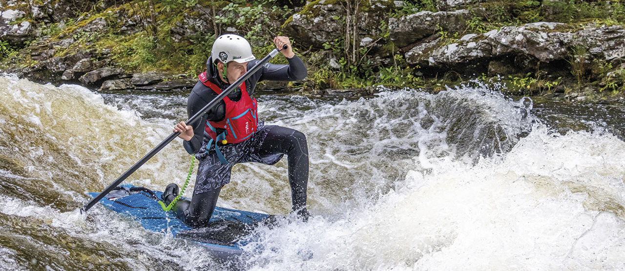 Photo: Budd dropping to one knee on the River Garry, Whitebridge Rapid. Photo: Jim Miller